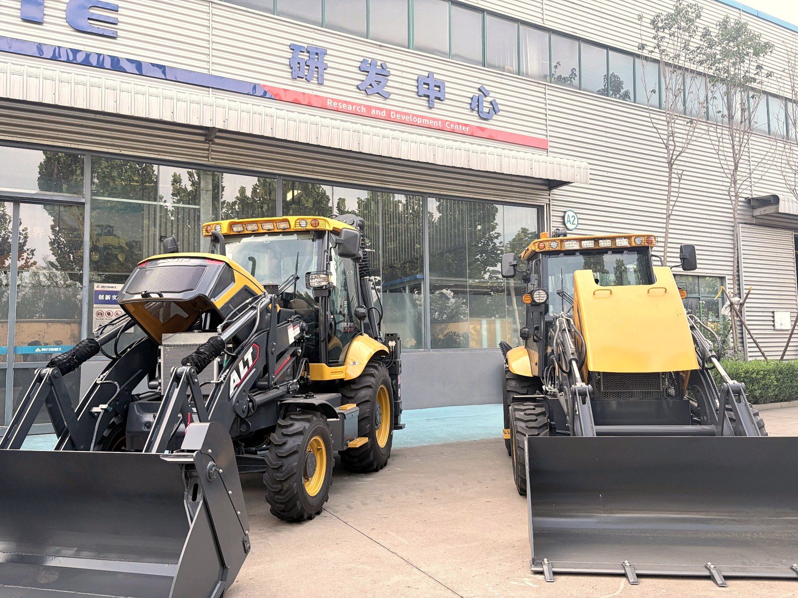 Two backhoe loaders parked in front of the R&D Center