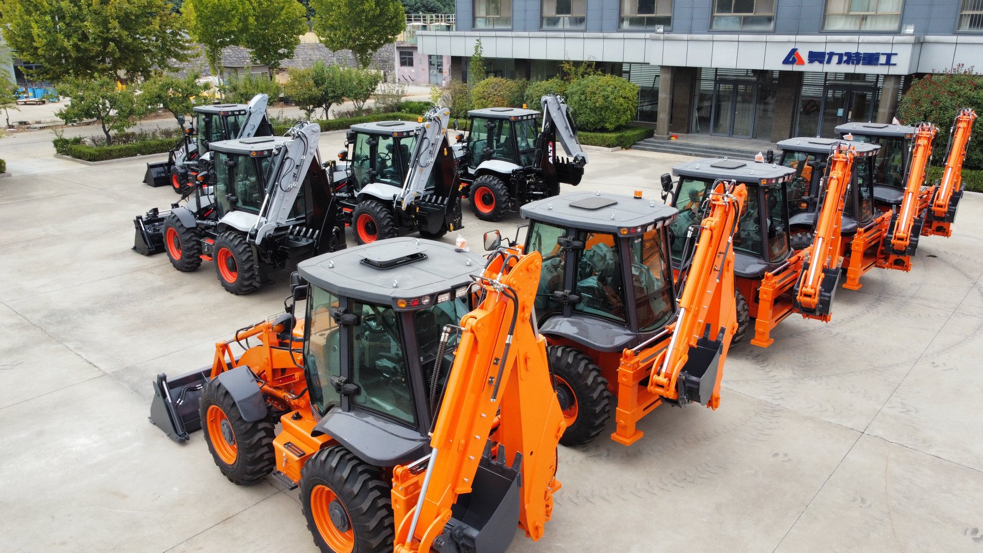 Backhoe loader fleet parked in front of the AOLITE Heavy Industry factory building