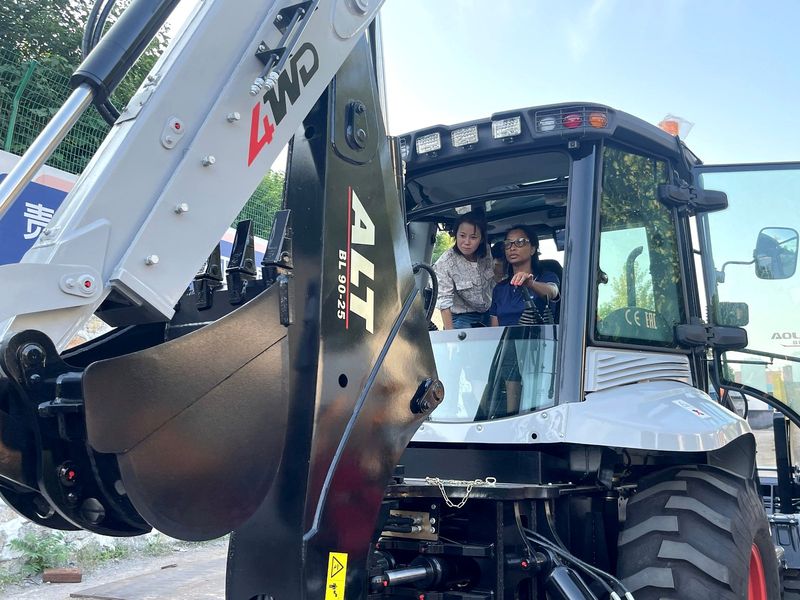 Client getting the hang of operating the machine — backhoe loader