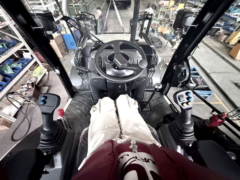 Operator cab interior with joystick controls — backhoe loader
