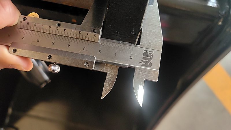 Vernier caliper measuring a critical component to spec
