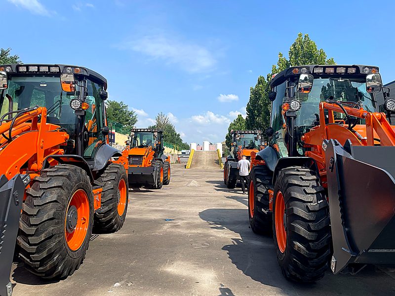 Backhoe loaders lined up at the test track for final inspection