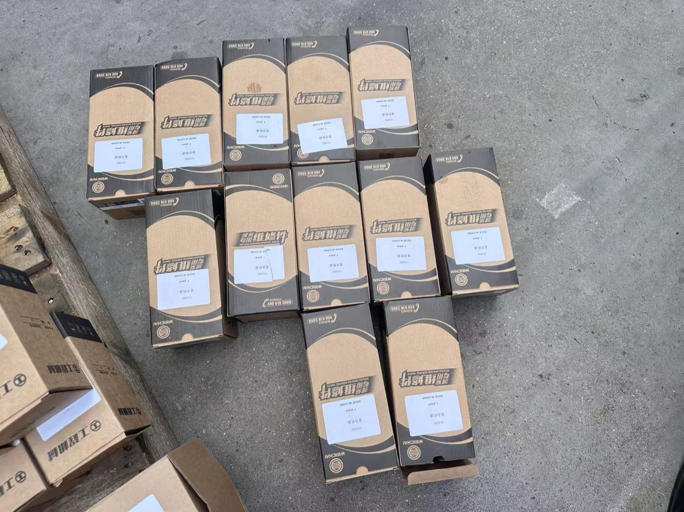 Spare parts boxes for backhoe loaders laid out and labelled in the workshop before shipment