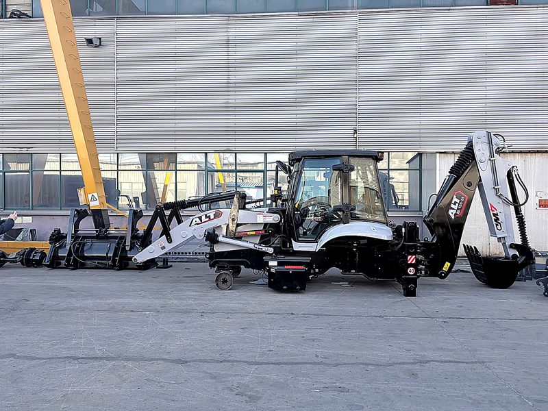 Backhoe loader parked outside the factory waiting to be loaded