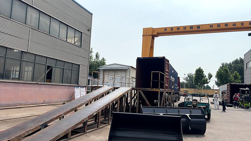 Gantry crane loading a container at the factory yard — backhoe loader