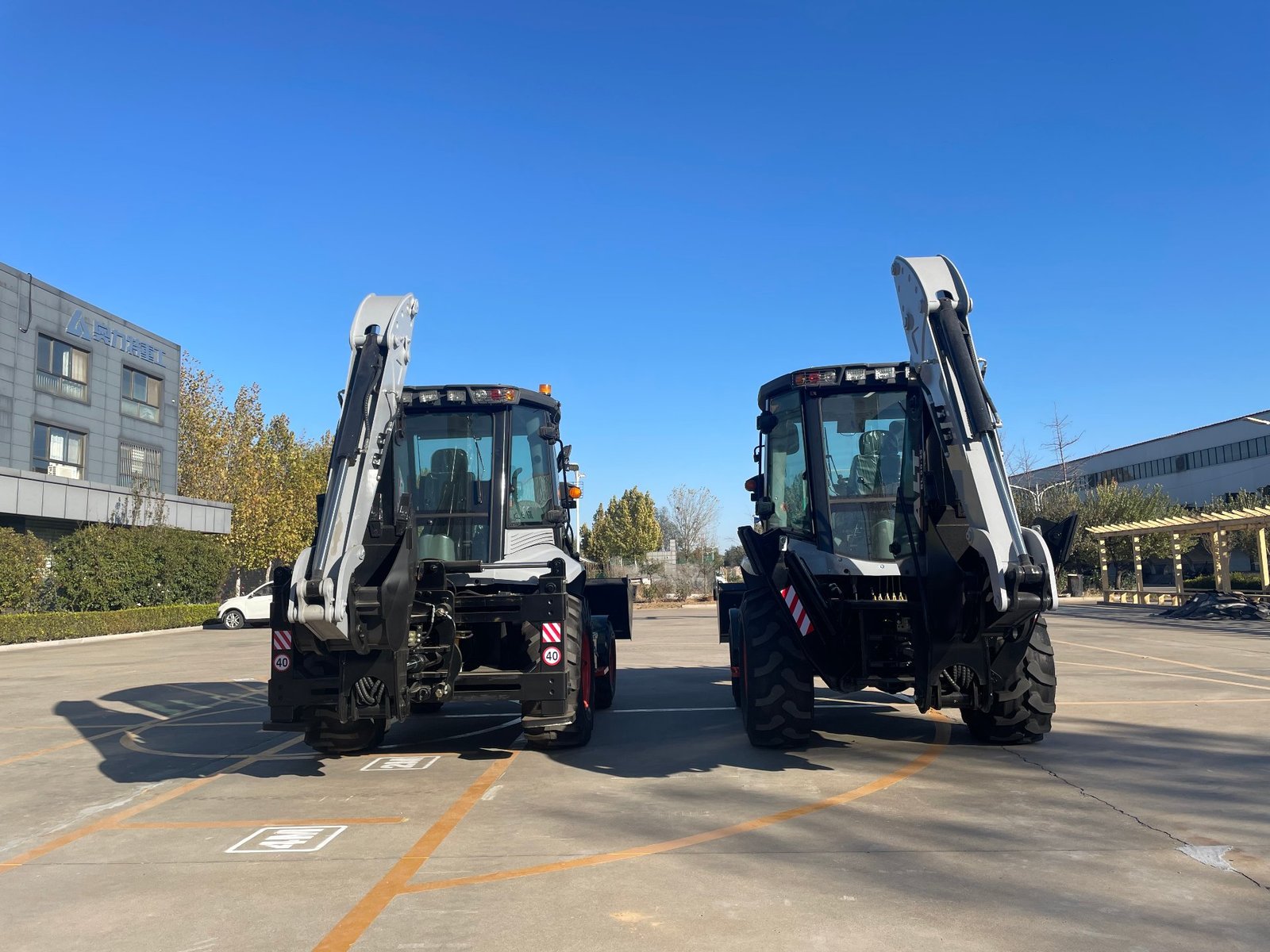 Two BL80-25 backhoe loaders lined up at the factory yard ready for dispatch