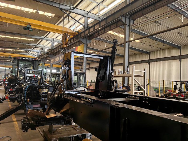 Backhoe loader frames being assembled on the workshop floor