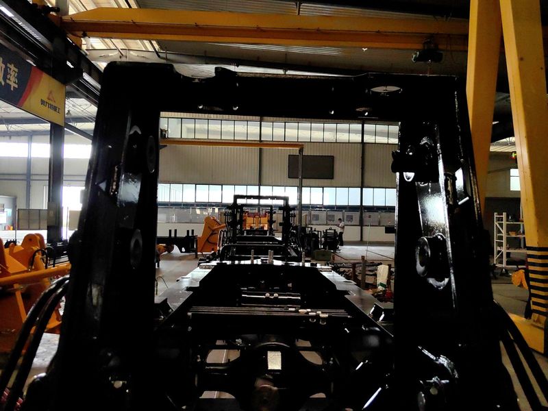 Looking through a backhoe loader frame into the workshop